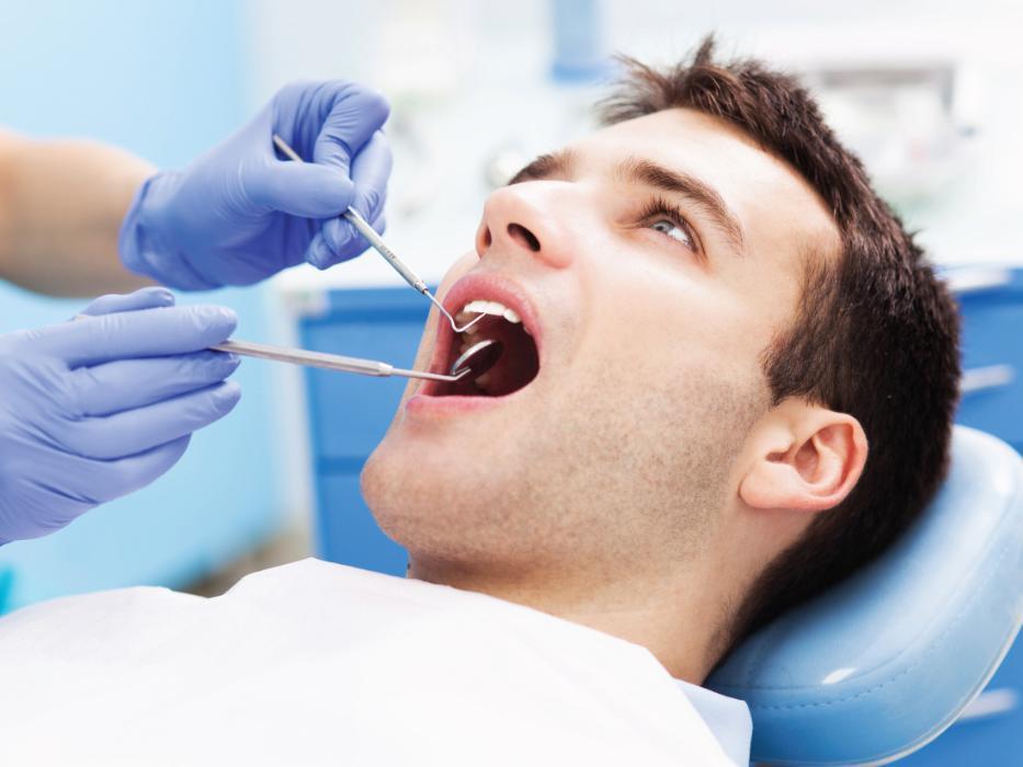 man getting dental work in dental exam chair l emergency dentistry wylie tx