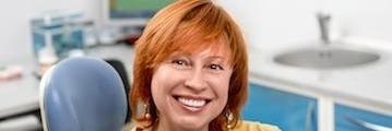 smiling woman sitting in dental exam chair l dentist near me