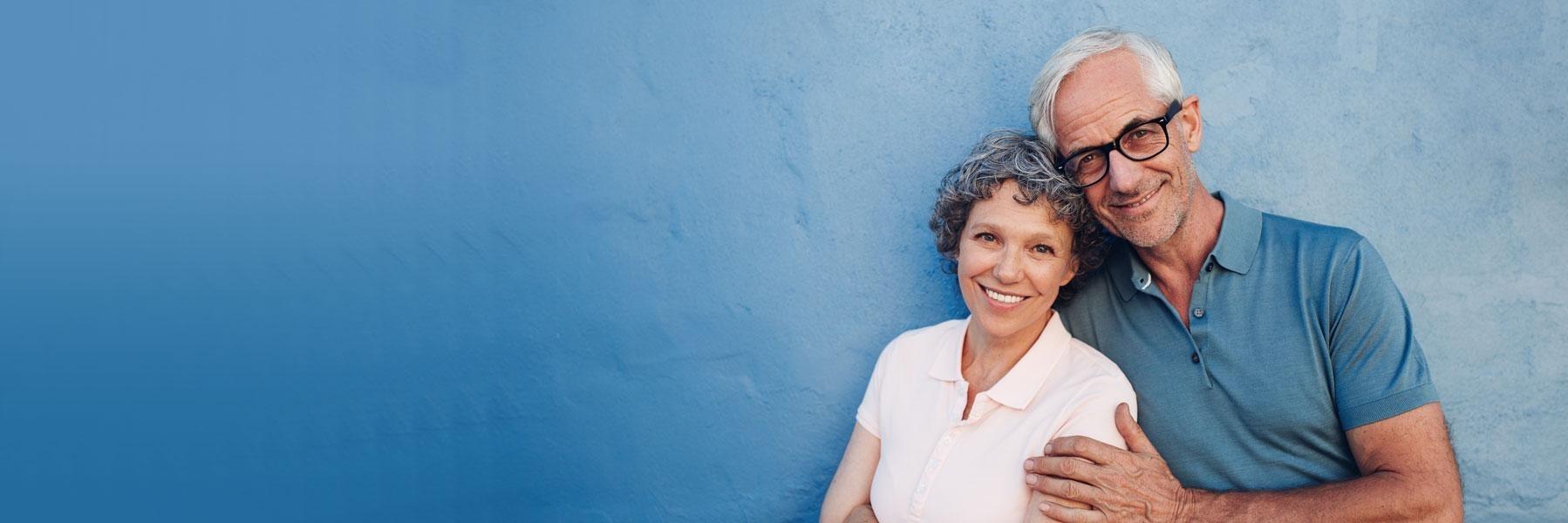 older couple with blue background smiling l wylie dental